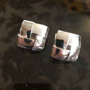 A pair of clip on silver tone woven square earrings.